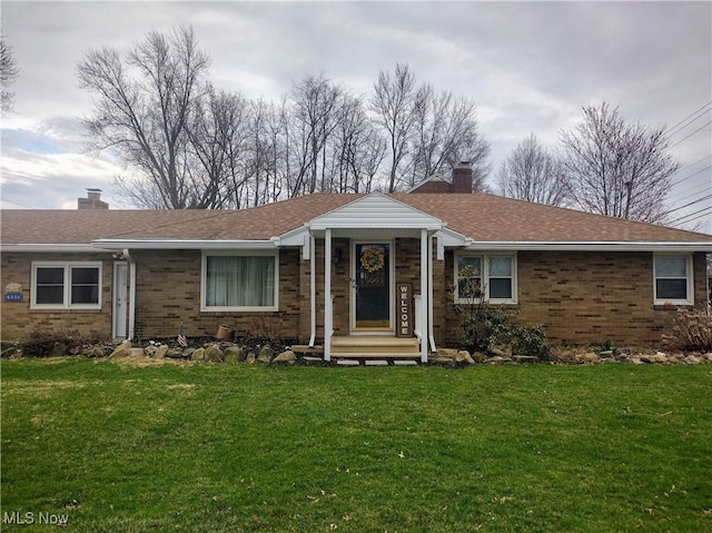 ranch-style house with brick siding, a front lawn, and a chimney