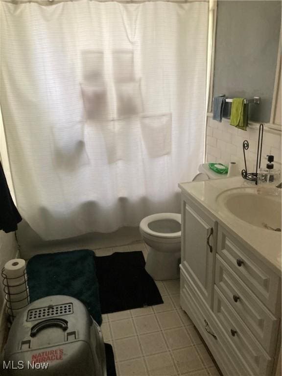 2628 Euclid Heights Blvd, Cleveland Heights, OH 44106 - bathroom with toilet, vanity, shower / tub combo with curtain, decorative backsplash, and tile patterned floors