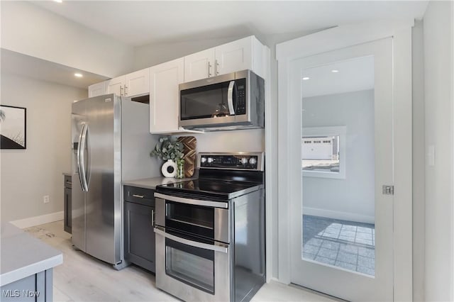 kitchen featuring recessed lighting, baseboards, white cabinetry, light countertops, and appliances with stainless steel finishes