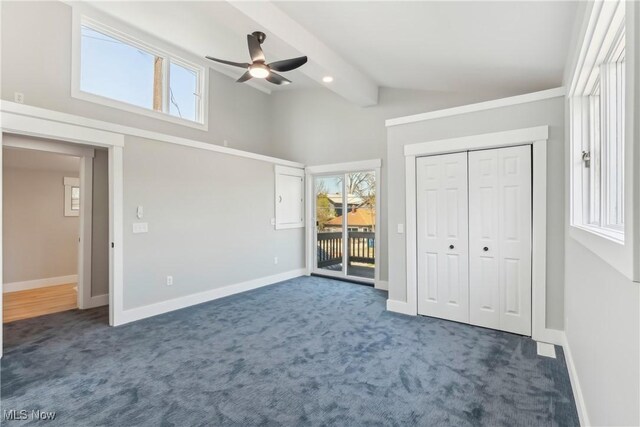 unfurnished bedroom featuring ceiling fan, access to outside, vaulted ceiling with beams, dark colored carpet, and baseboards