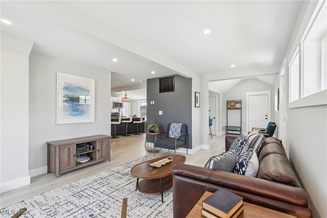living room with light wood-style floors, plenty of natural light, recessed lighting, and baseboards