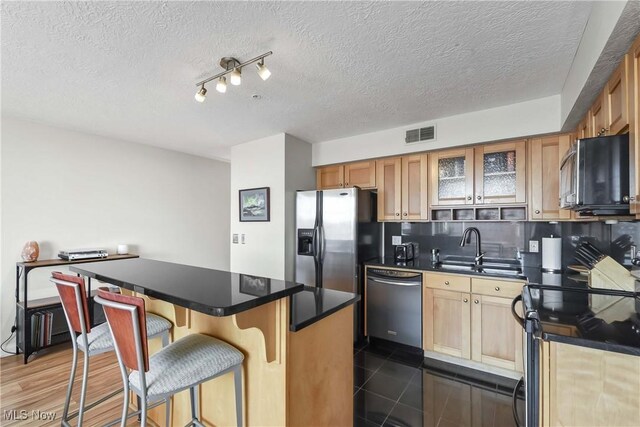 kitchen featuring stainless steel appliances, a center island, a breakfast bar, visible vents, and backsplash