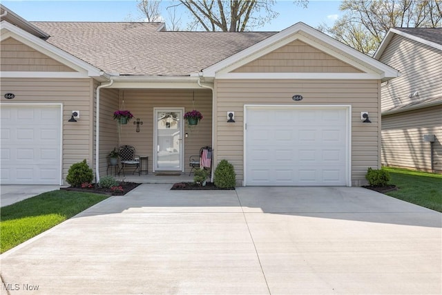 view of front of property featuring a garage, a shingled roof, and driveway