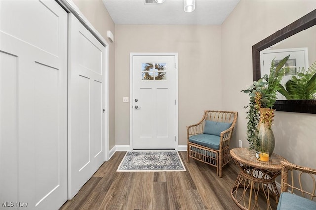interior space featuring baseboards, visible vents, and wood finished floors