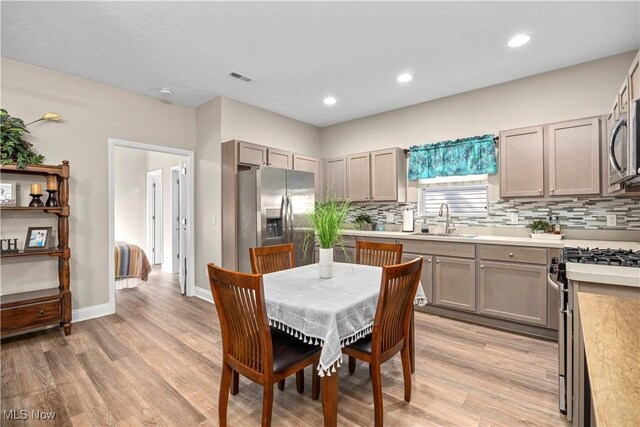 dining room featuring visible vents, light wood-style flooring, and recessed lighting