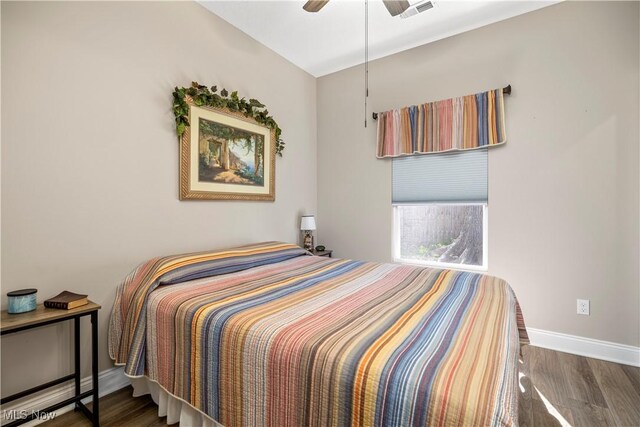 bedroom featuring wood finished floors, visible vents, ceiling fan, and baseboards
