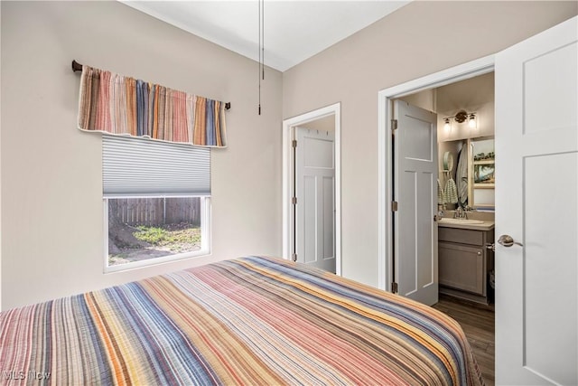 bedroom with a sink and wood finished floors