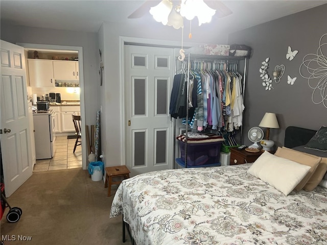 bedroom with ceiling fan, light carpet, and a closet