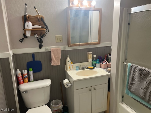 bathroom with a wainscoted wall, toilet, and vanity