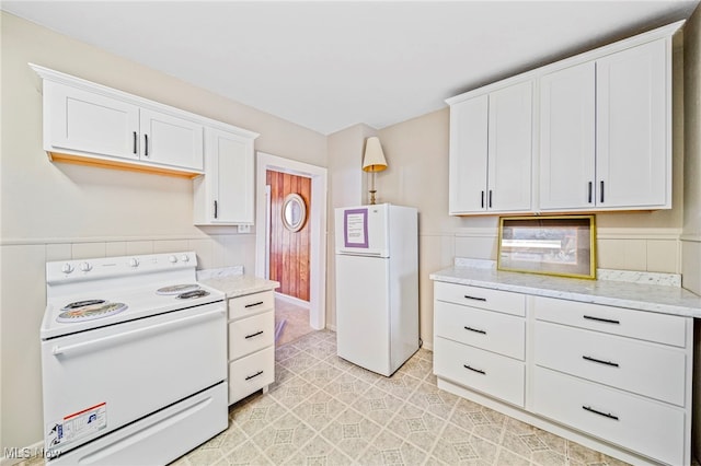 1420 Bridge St, Ashtabula, OH 44004 - kitchen with white cabinets, white appliances, and light stone counters