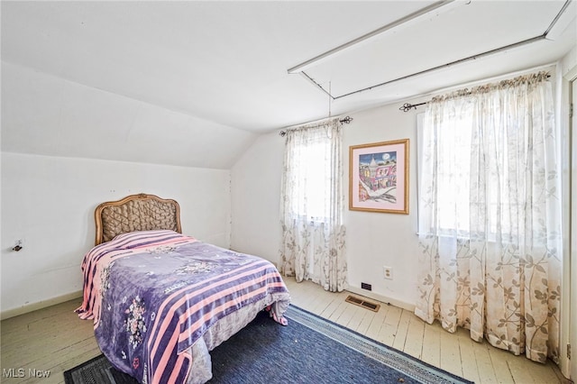1420 Bridge St, Ashtabula, OH 44004 - bedroom featuring attic access, wood-type flooring, visible vents, vaulted ceiling, and baseboards