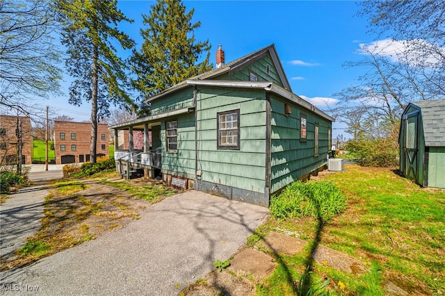 1420 Bridge St, Ashtabula, OH 44004 - view of side of home featuring central AC unit and a chimney