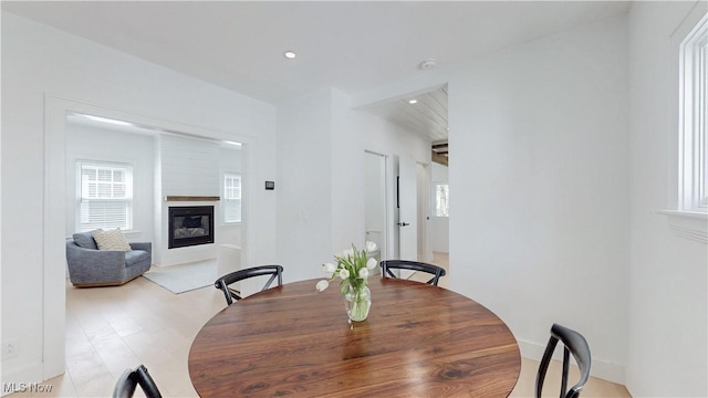 dining space featuring a glass covered fireplace and recessed lighting