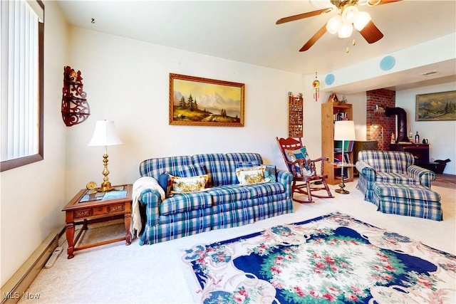 carpeted living room with a wood stove, ceiling fan, and baseboard heating