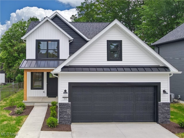 modern farmhouse with fence, roof with shingles, a standing seam roof, and a garage