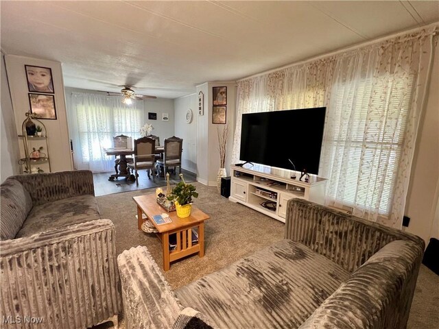 carpeted living room with ceiling fan