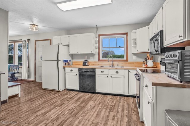 39233 Jones Rd, Litchfield, OH 44253 - kitchen with black appliances, a wealth of natural light, wood counters, and a sink