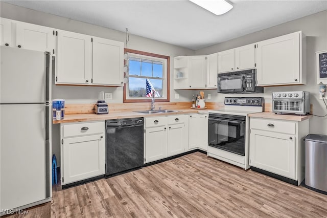 39233 Jones Rd, Litchfield, OH 44253 - kitchen with black appliances, light countertops, light wood finished floors, and a sink
