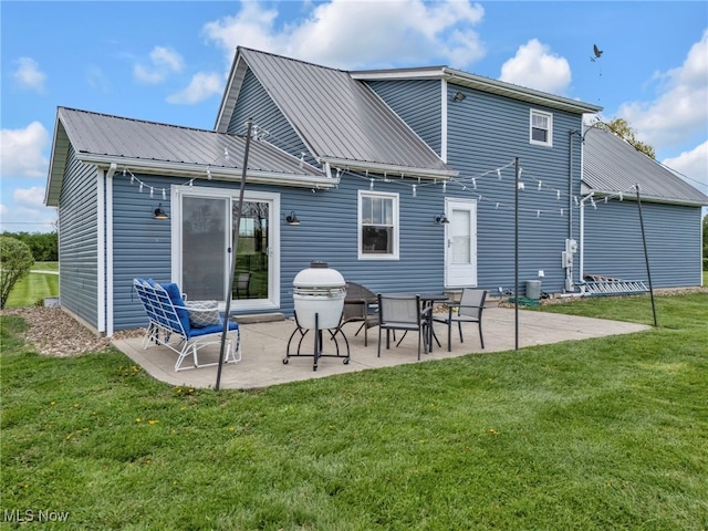 39233 Jones Rd, Litchfield, OH 44253 - rear view of property featuring metal roof, a lawn, and a patio