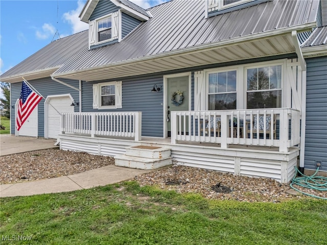 39233 Jones Rd, Litchfield, OH 44253 - property entrance featuring a garage, a porch, driveway, and metal roof