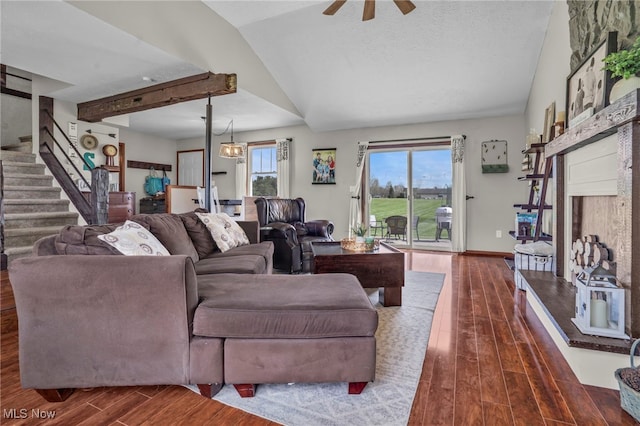 39233 Jones Rd, Litchfield, OH 44253 - living room featuring stairway, ceiling fan, a fireplace with raised hearth, vaulted ceiling, and dark wood-type flooring