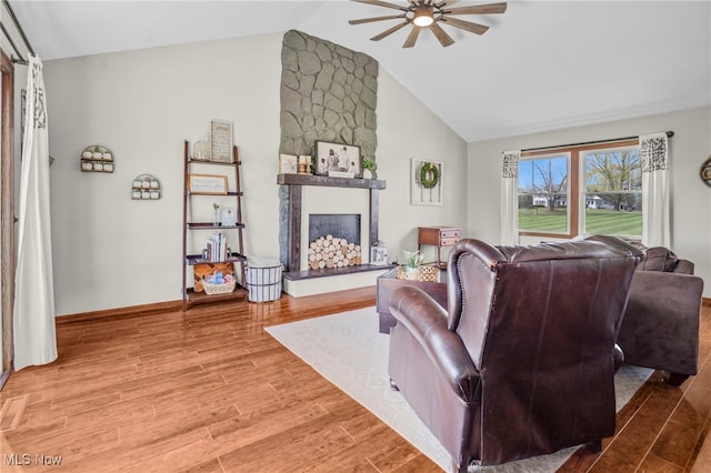 39233 Jones Rd, Litchfield, OH 44253 - living area featuring light wood-style flooring, ceiling fan, a fireplace, baseboards, and high vaulted ceiling