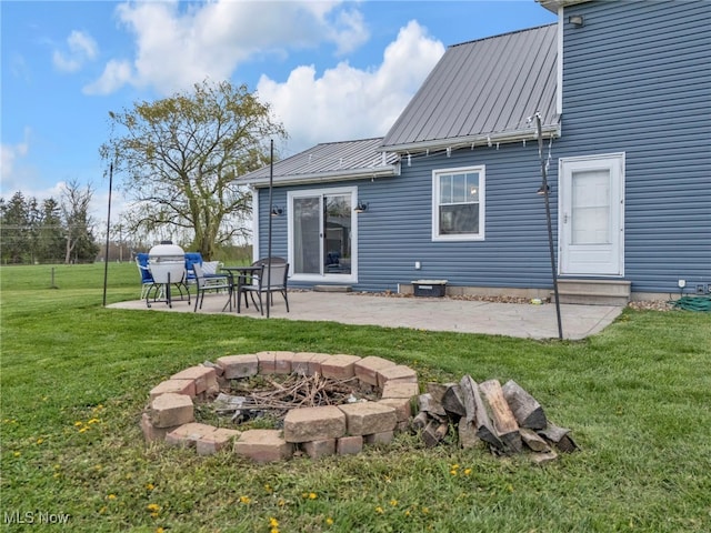 39233 Jones Rd, Litchfield, OH 44253 - rear view of property with a patio, an outdoor fire pit, metal roof, and a lawn
