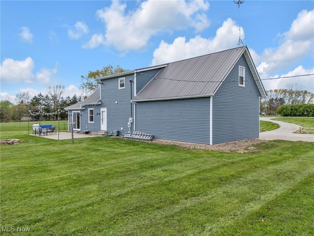39233 Jones Rd, Litchfield, OH 44253 - back of house with metal roof, a yard, and a patio area