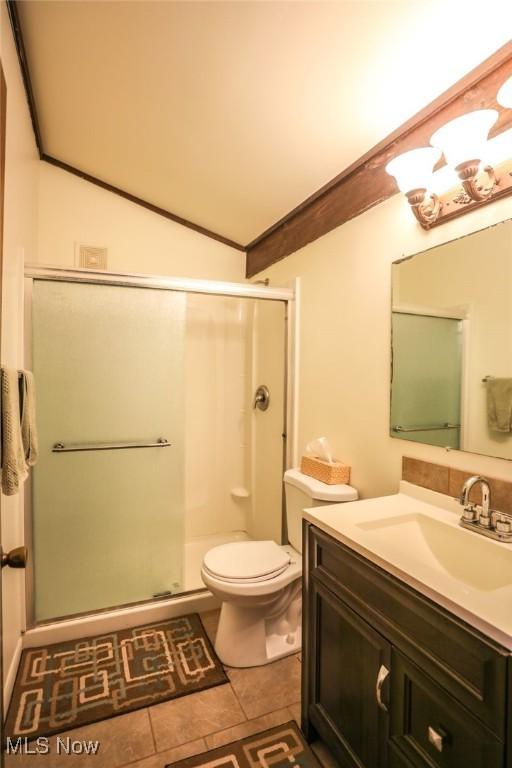 full bath featuring toilet, tile patterned flooring, a shower stall, and lofted ceiling