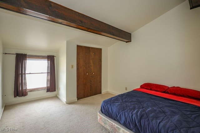 bedroom featuring baseboards, beamed ceiling, and carpet flooring