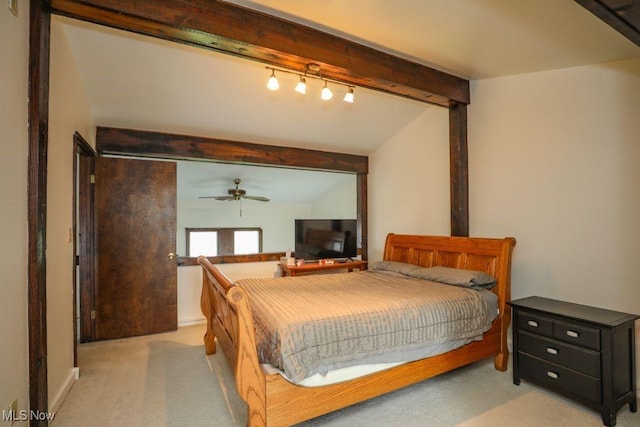 bedroom featuring beam ceiling, light colored carpet, and track lighting