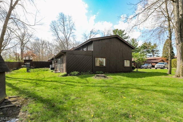 rear view of property featuring fence and a yard