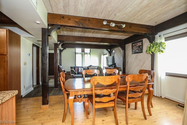 dining space with beamed ceiling and light wood-style flooring