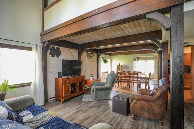living room featuring beamed ceiling, arched walkways, wood walls, and wood finished floors