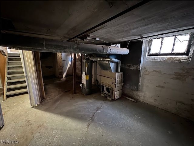 basement with heating unit, water heater, and stairway
