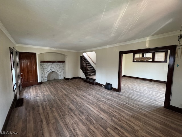 unfurnished living room with baseboards, ornamental molding, a fireplace, wood finished floors, and stairs