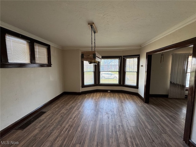 unfurnished dining area with dark wood finished floors, visible vents, crown molding, and baseboards