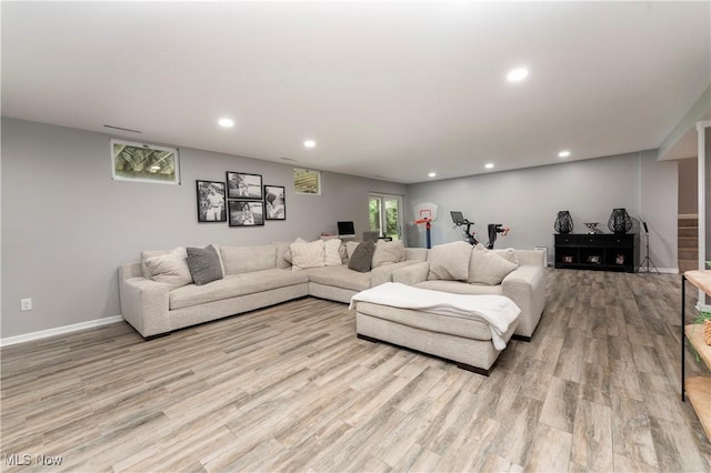 living room featuring baseboards, recessed lighting, and light wood-style floors