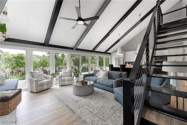 living area with stairway, a ceiling fan, high vaulted ceiling, and beamed ceiling