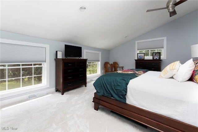 bedroom featuring light colored carpet, visible vents, a ceiling fan, and vaulted ceiling