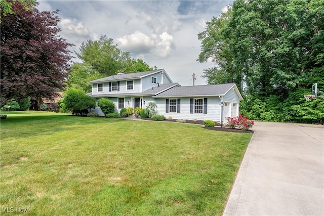 view of front facade with a front yard, an attached garage, and concrete driveway