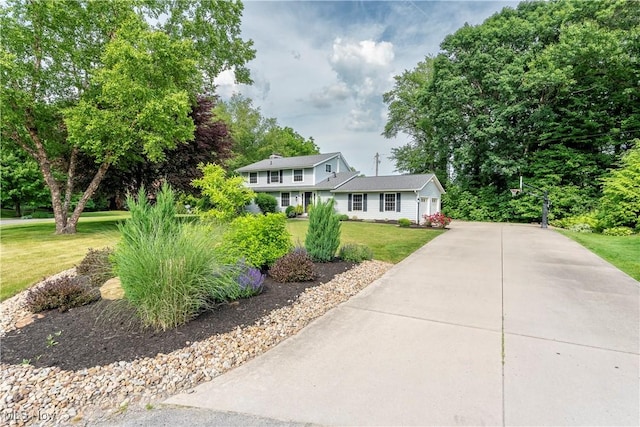 view of front of property featuring a front lawn and concrete driveway