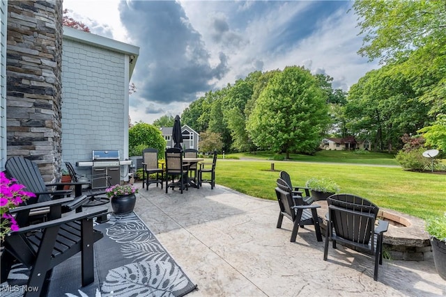 view of patio with area for grilling, an outdoor fire pit, and outdoor dining area