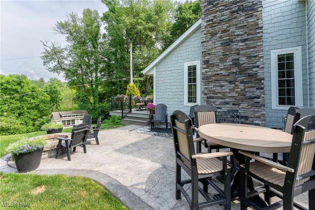 view of patio / terrace featuring a deck, an outdoor fire pit, and outdoor dining space