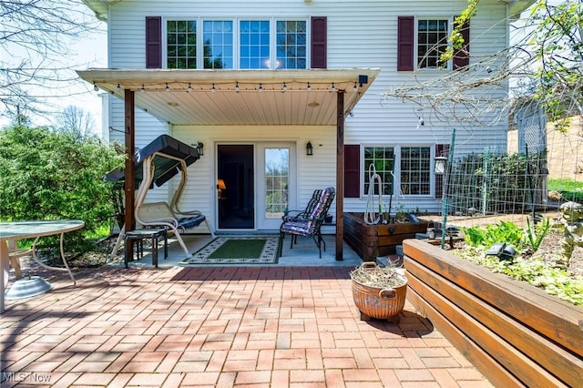 rear view of property featuring a patio area and a vegetable garden