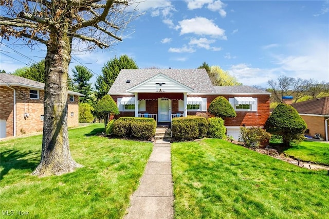 bungalow featuring covered porch, brick siding, and a front yard