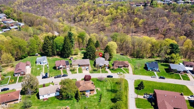 birds eye view of property featuring a residential view and a wooded view