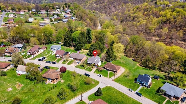 drone / aerial view featuring a residential view and a wooded view