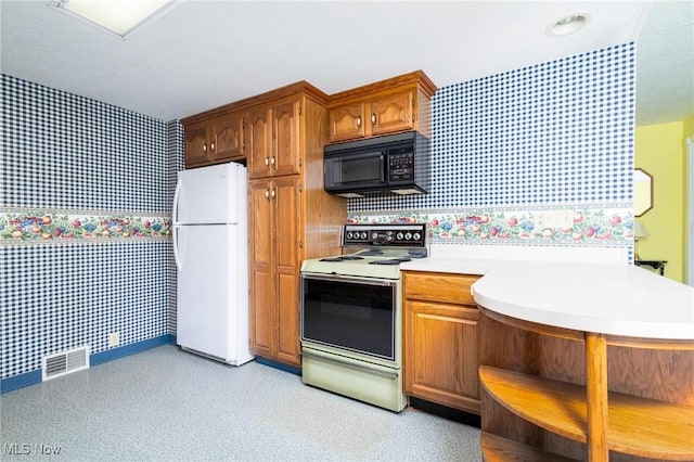 kitchen featuring visible vents, wallpapered walls, white appliances, and light countertops