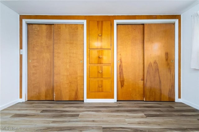 265 Putnam Ln, Weirton, WV 26062 - unfurnished bedroom featuring two closets, baseboards, and wood finished floors